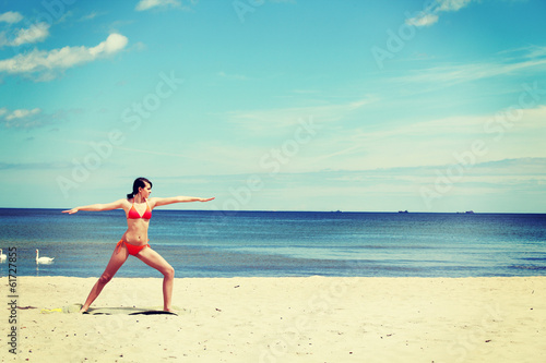 Athletic  fit young woman  is training exercises on the beach.