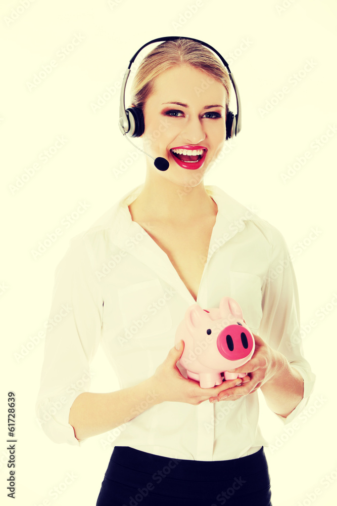 Young businesswoman with headset holding piggy bank Young businesswoman with headset holding piggy bank