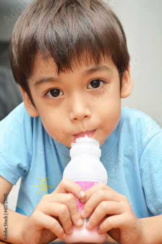 Little boy drinking milk strawberry favor