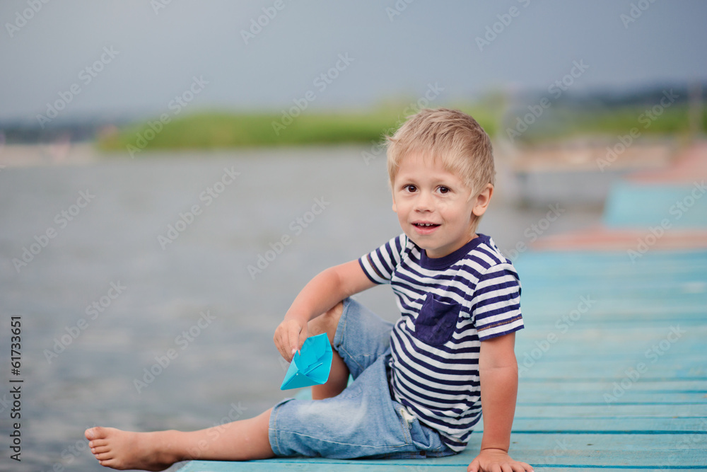 boy of four on jetty by the sea