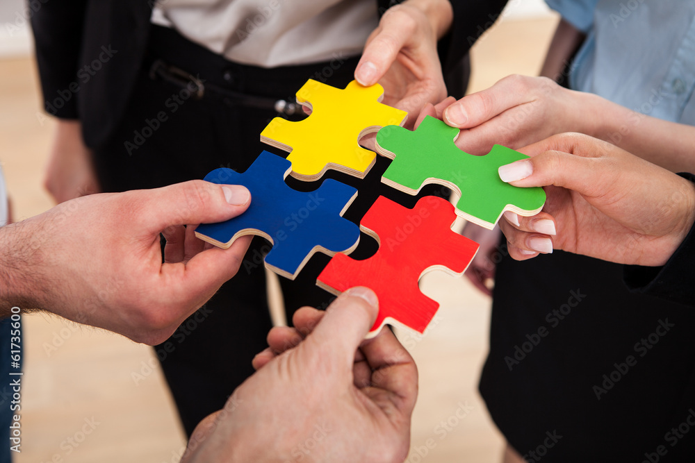 Businesspeople Assembling Jigsaw Puzzle Businesspeople Assembling Jigsaw Puzzle