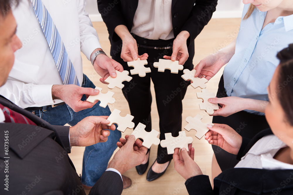 © Andrey Popov - Business People Holding Jigsaw Puzzle