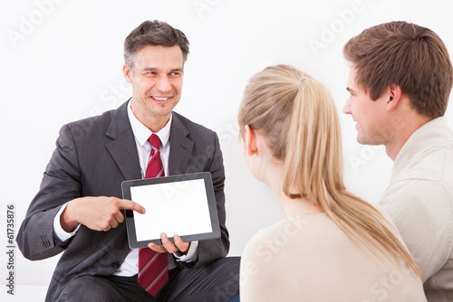 Salesman Showing Tablet Pc To Couple