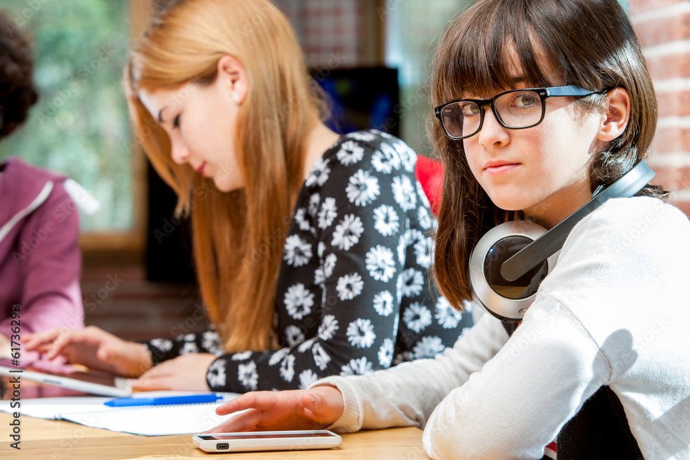 Cute girl with friends at schoolwork table. Cute girl with friends at schoolwork table.