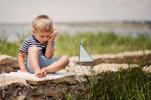 boy of four on jetty by the sea