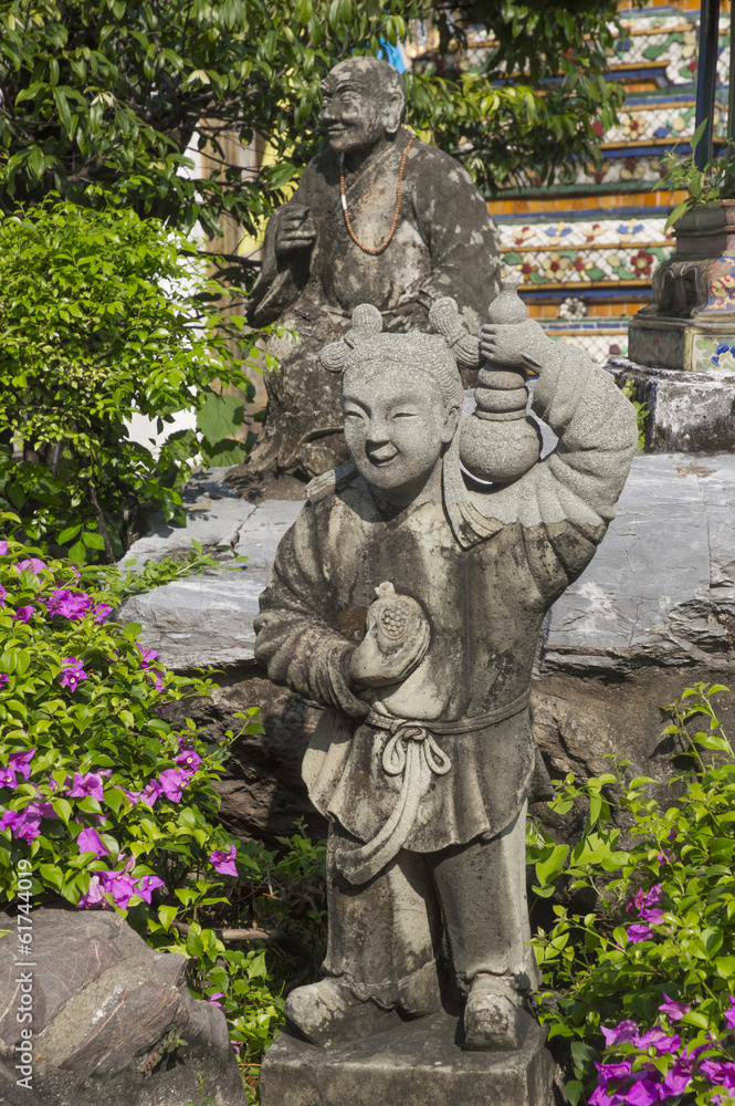 Statue of little Chinese girl with a monk in green garden in Ban Statue of little Chinese girl with a monk in green garden in Ban