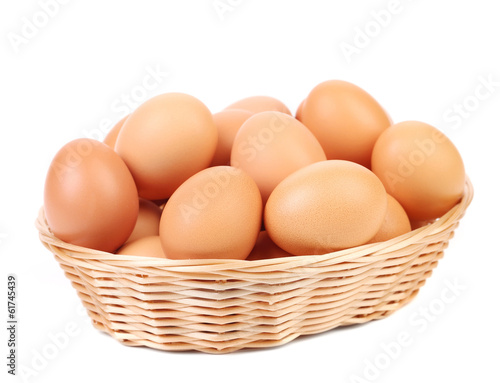 Brown eggs in the basket on a white. © indigolotos