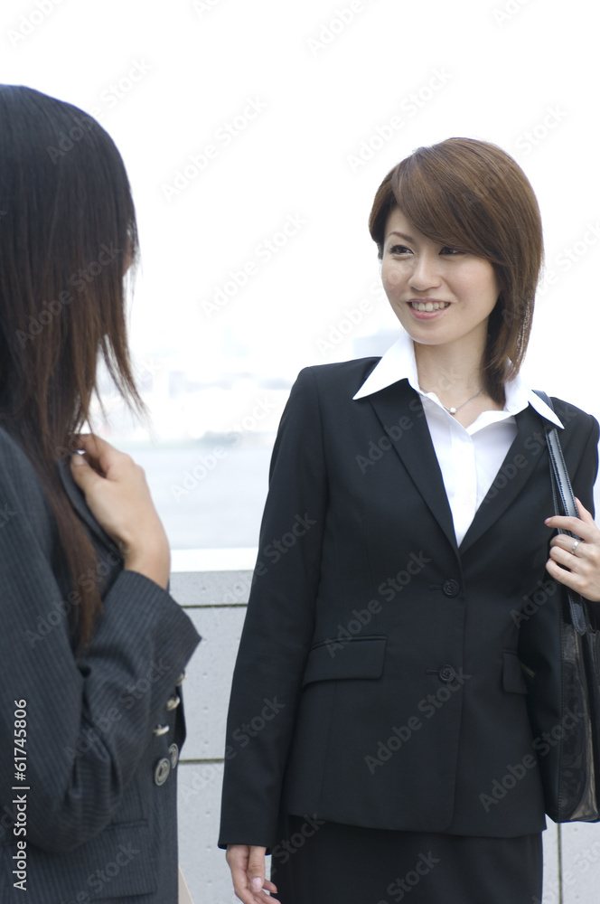 Two Japanese women in their twenties talking outside Two Japanese women in their twenties talking outside