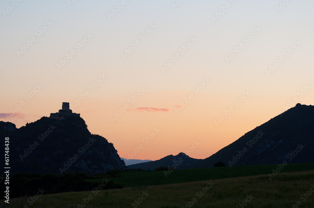 silhouette of a castle on a hill, at sunset