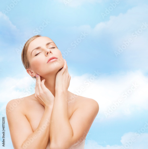 beautiful woman touching her face with closed eyes