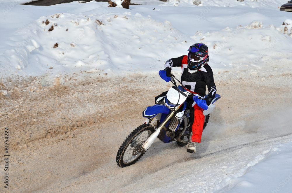 Motocross on snow racer on a motorcycle in the left turn having Motocross on snow racer on a motorcycle in the left turn having