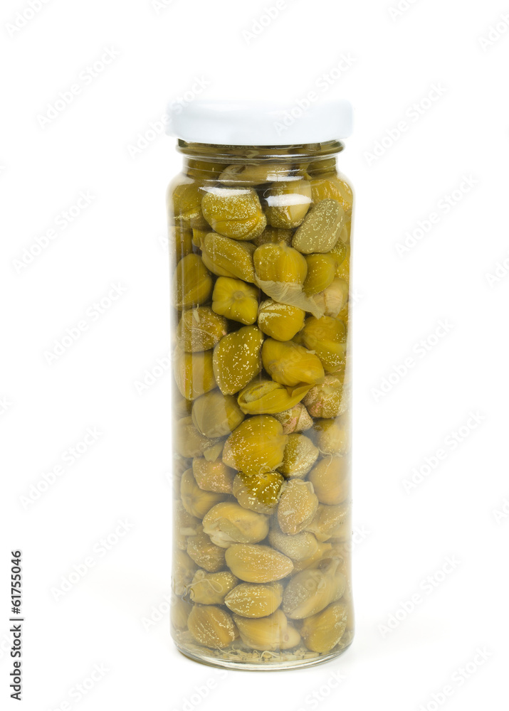 capers in a glass jar isolated on white capers in a glass jar isolated on white