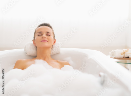 Tela Young woman relaxing in bathtub