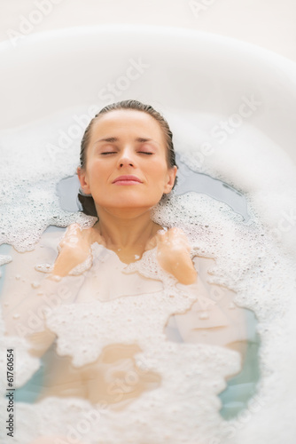 Young woman laying in bathtub