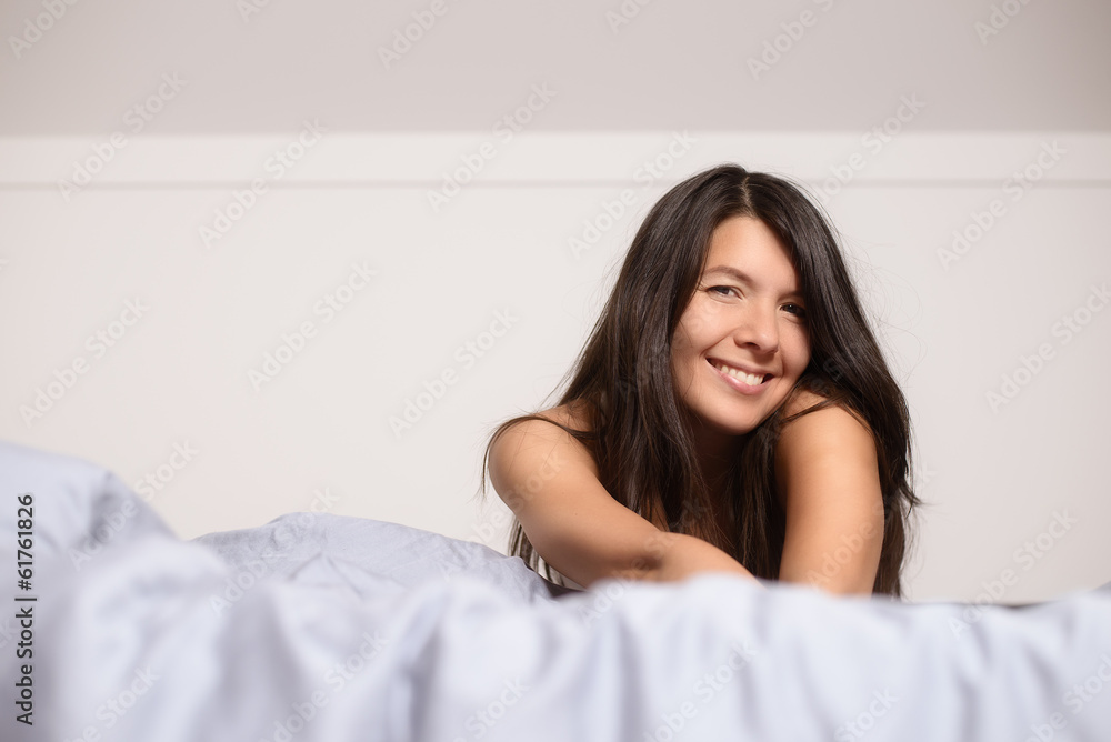 Lächelnde attraktive Frau im Bett genießt den Tag Lächelnde attraktive Frau im Bett genießt den Tag