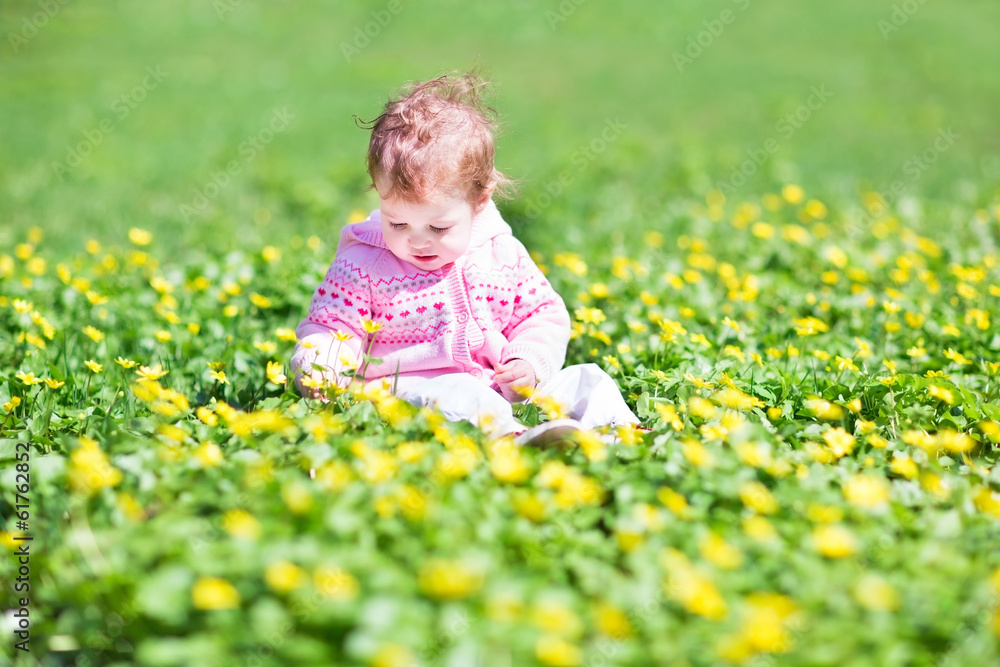 Little girl playing in the garden with many yellow flowers Little girl playing in the garden with many yellow flowers