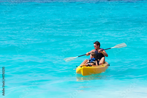 Father and son on a kayak ride in a tropical blue sea © famveldman