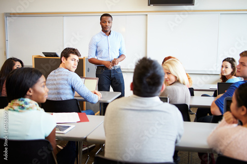 Male Tutor Teaching University Students In Classroom