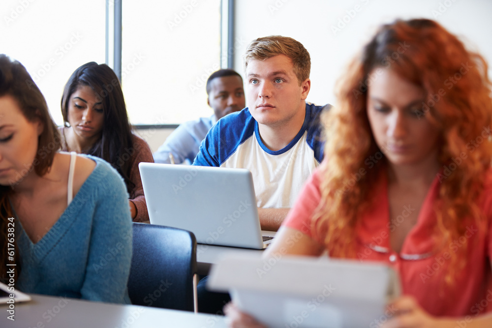 Male University Student Using Laptop In Classroom Male University Student Using Laptop In Classroom
