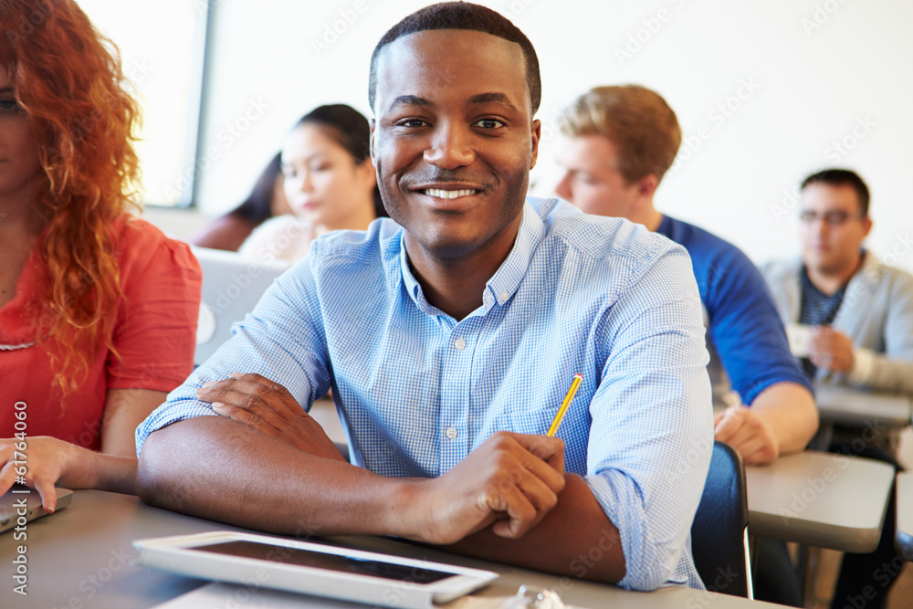 Male University Student Using Digital Tablet In Classroom Male University Student Using Digital Tablet In Classroom