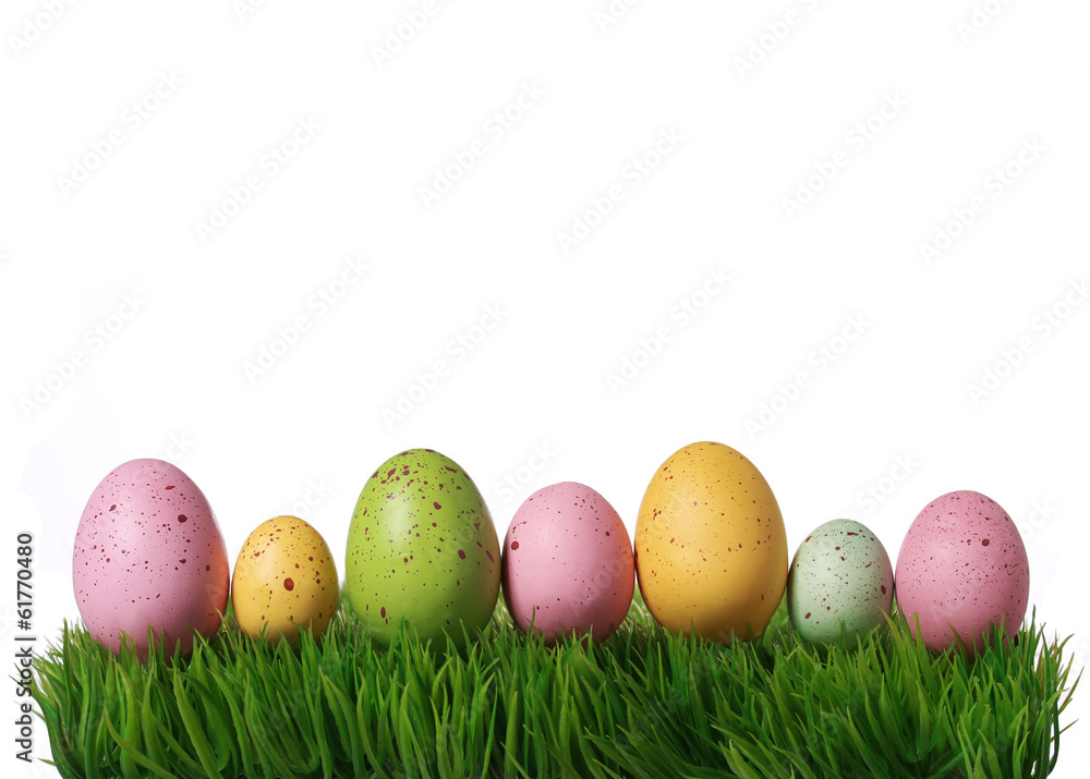 Colorful easter eggs on green grass isolated on white