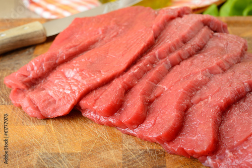 Fettine di carne di manzo crude sul tagliere di legno