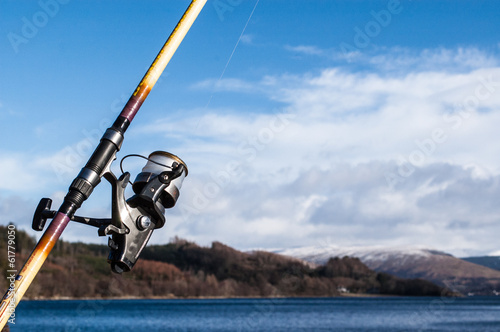 Fishing reel and rod with sea, sky and mountain