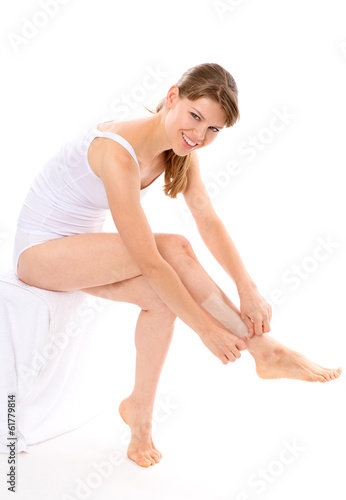 Skin care. Pretty woman removing hair from her legs, isolated