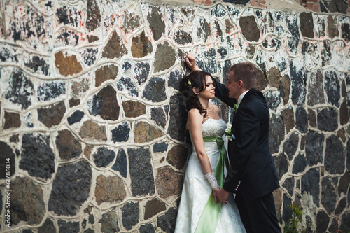 Fototapeta Naklejka Na Ścianę i Meble -  wedding. husband and wife on the stone wall background