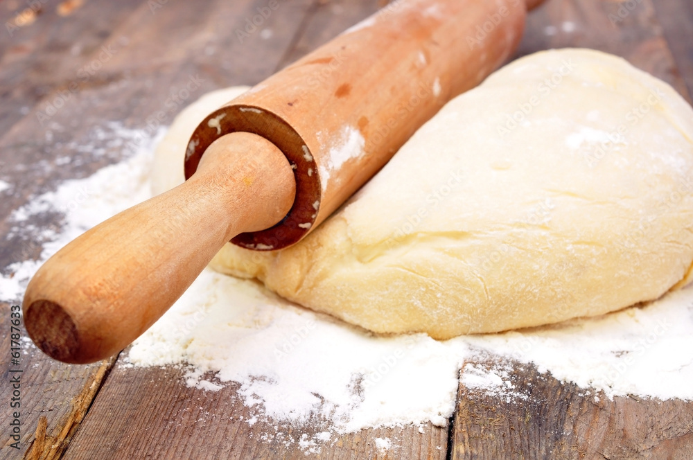 rolling pin and dough on a wooden table rolling pin and dough on a wooden table