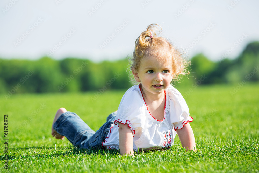 Fototapeta premium Little happy girl on a grass