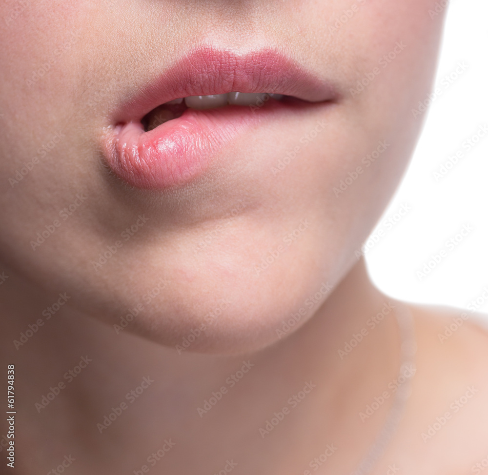Young woman bites her lips closeup.