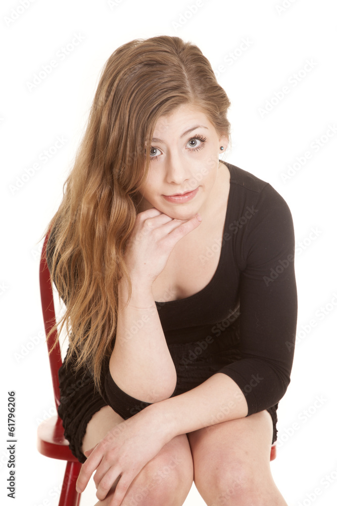 woman black dress red chair lean forward