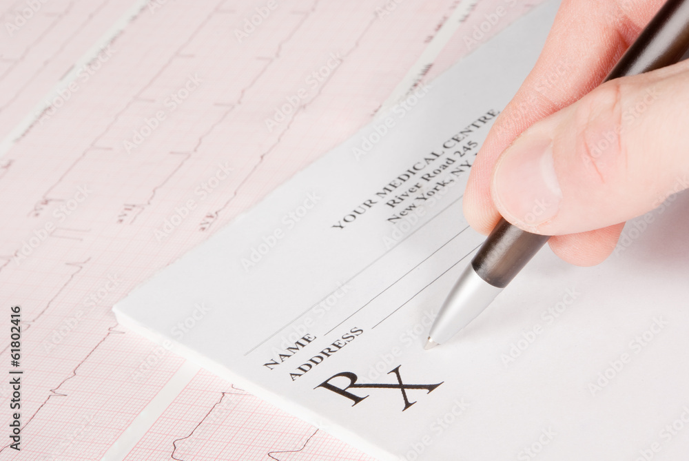 Doctor filling in empty medical prescription on ECG Doctor filling in empty medical prescription on ECG