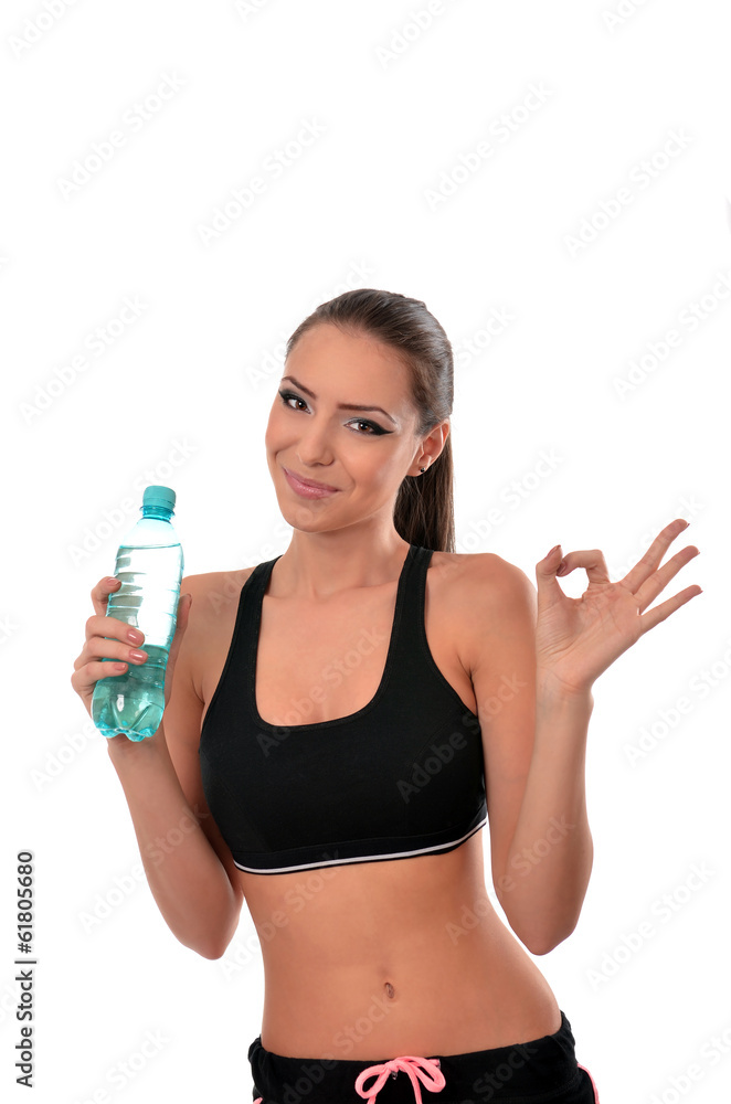 Fitness lady holding a bottle of water and giving the ok sign Fitness lady holding a bottle of water and giving the ok sign