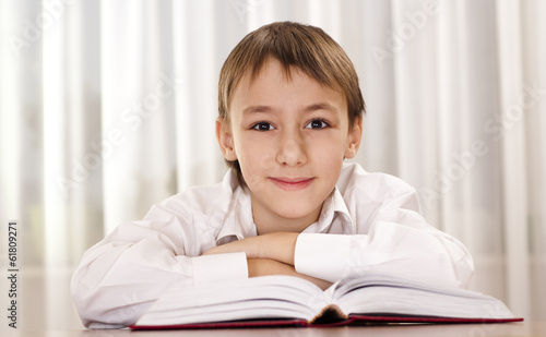Young boy in white shirt reading