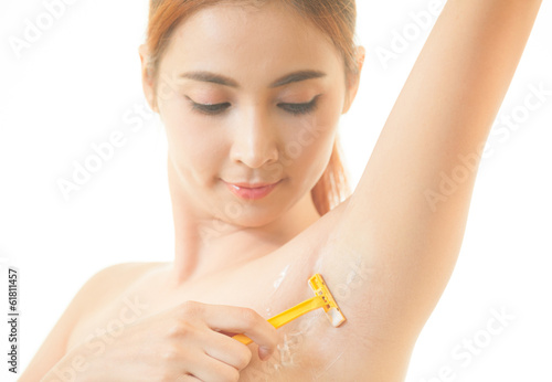 Woman shaving armpit with razor isolated