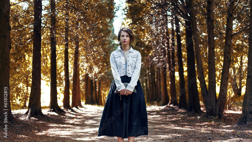 Beautiful girl hipster is on the road in the woods Beautiful girl hipster is on the road in the woods