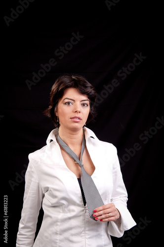 Young brunette woman in white shirt and tie posing in studio