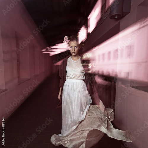 Beautiful girl on the move at night on the street in a  dress