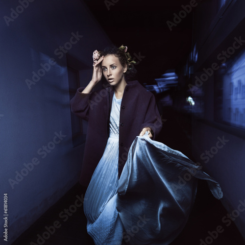 Beautiful girl on the move at night on the street in a  dress