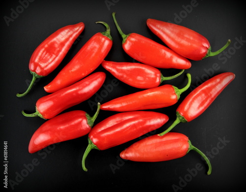 Red hot chili peppers on black background.