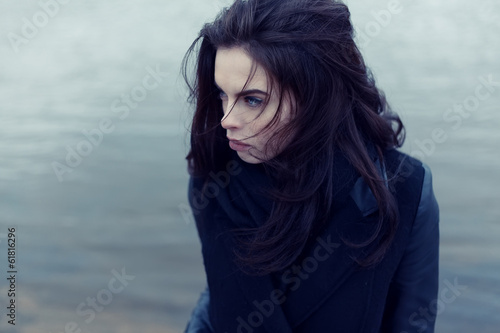 Beautiful fashionable girl in autumn coat near the water © maksimshirkov