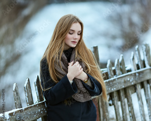 Beautiful young girl hot. Winter near the fence