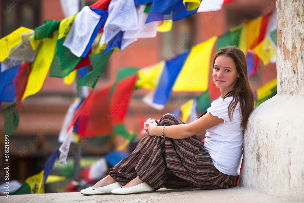 Young girl sitting on Buddhist stupa.