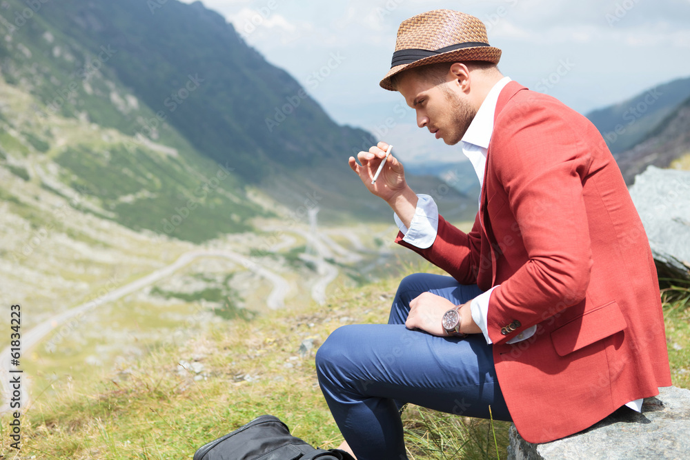 young fashion man smokes in nature young fashion man smokes in nature