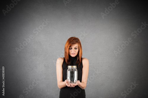 Fotografie Woman holding a pot with imprisoned man inside it against grunge