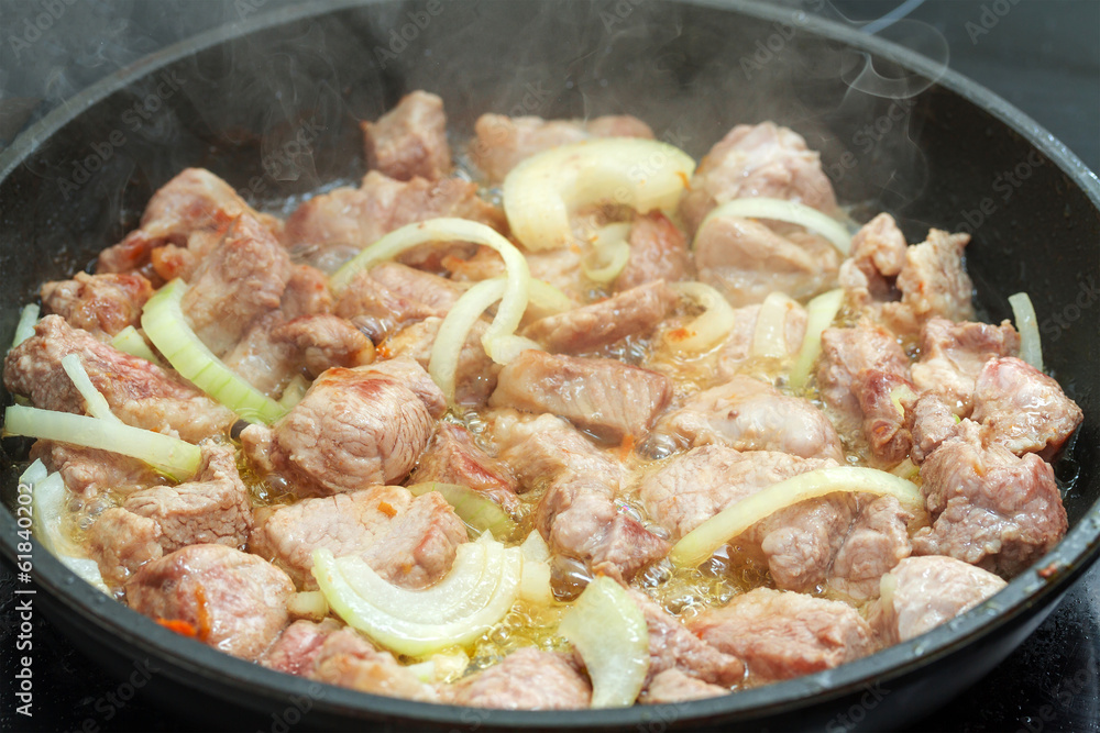 Fried meat with onion in a frying pan Fried meat with onion in a frying pan