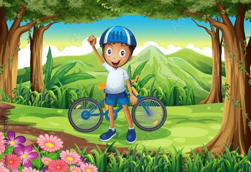 A happy boy with a bike standing in the middle of the forest