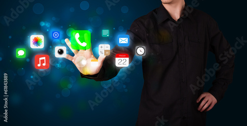 Handsome businessman pressing colorful mobile app icons with bok photo